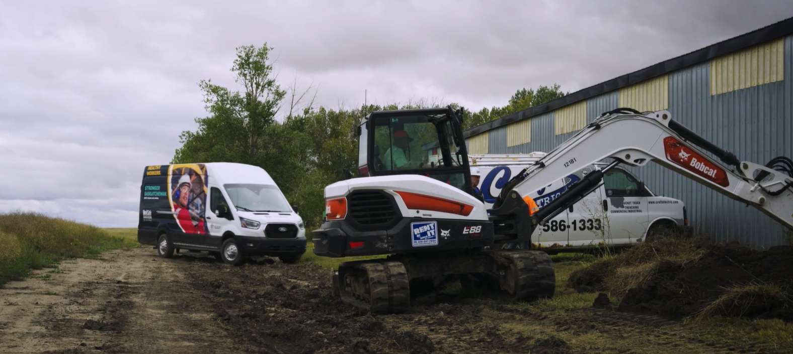 Mobile lab on location The Sask. Work mobile research lab on location next to a small backhoe.